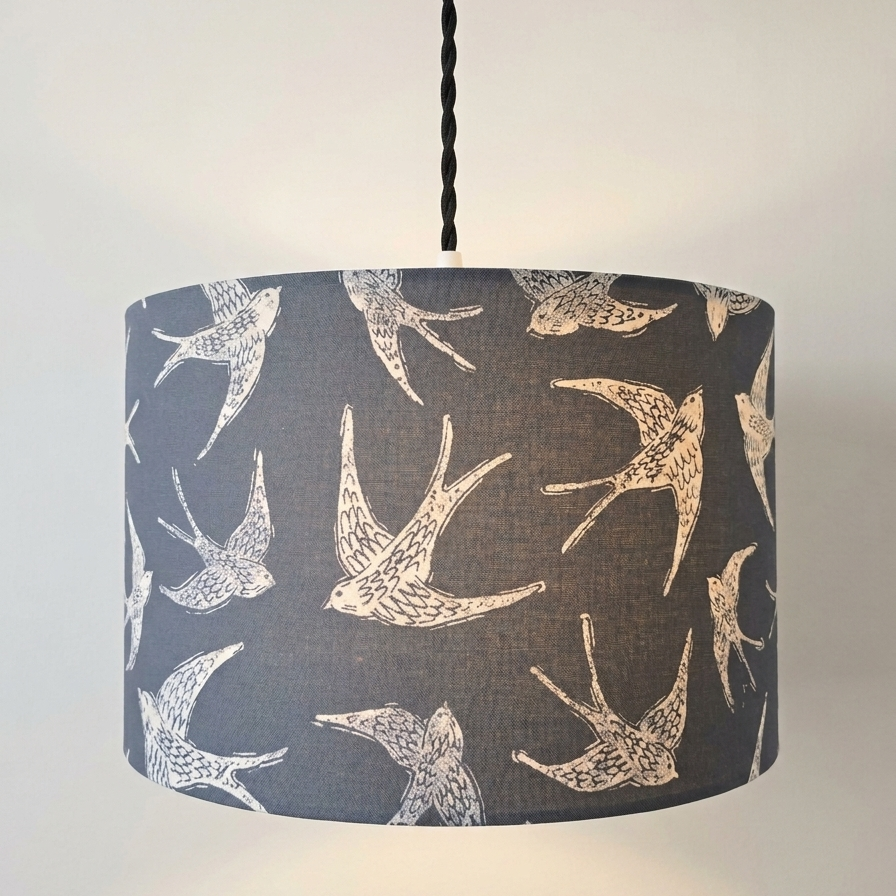 a handmade drum pendant lampshade in navy blue with swallow bird silhouette in white with hand drawn details. 